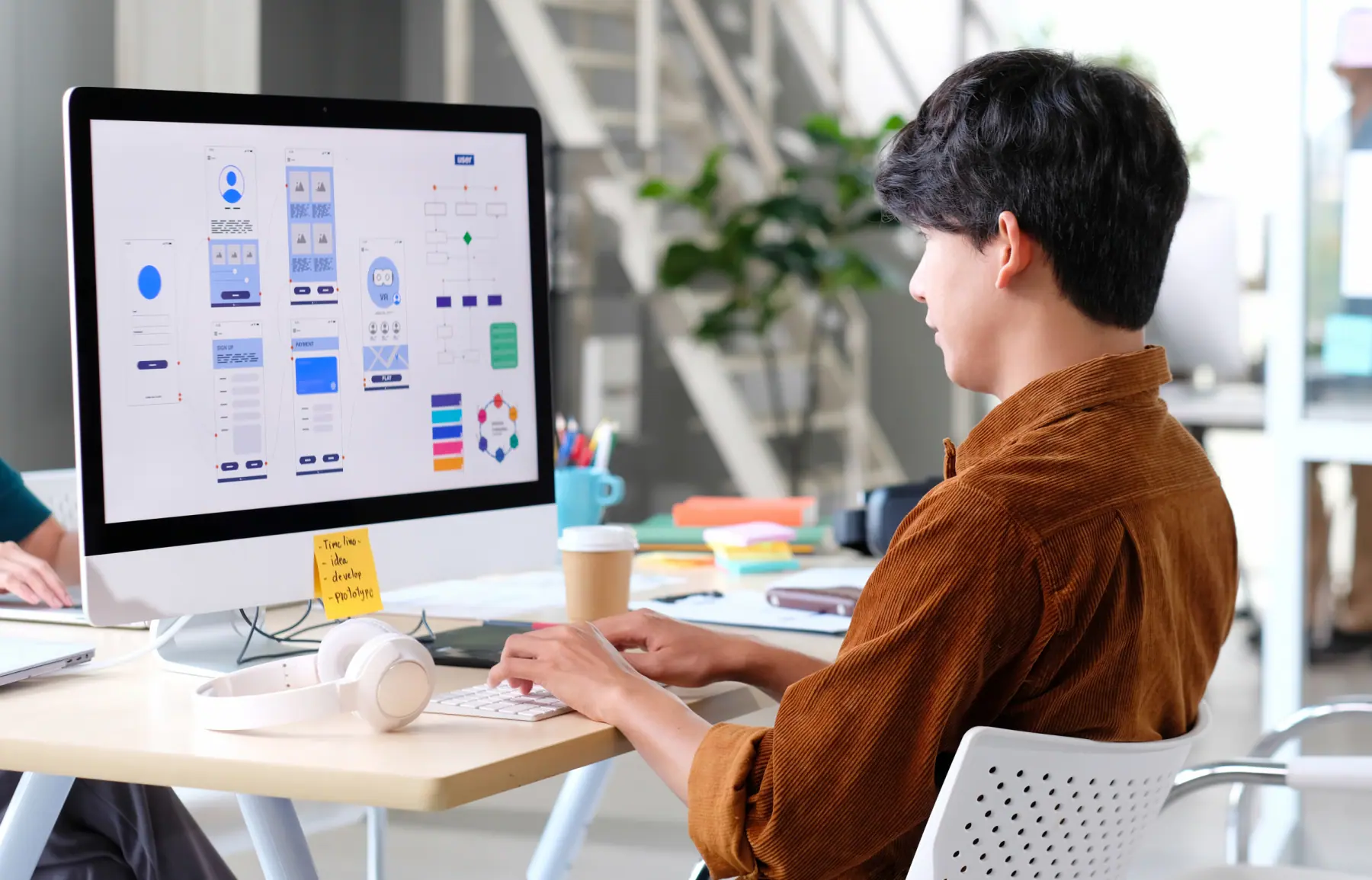 directeur artistique web travaillant sur une maquette ux/ui depuis son bureau nomade
